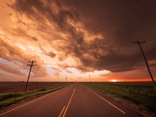 Great plains region highway with evening sunset clouds in the sky.